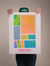 a woman is holding up a poster that says harvest