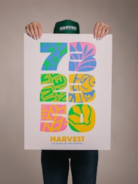 a woman holding up a poster that says harvest