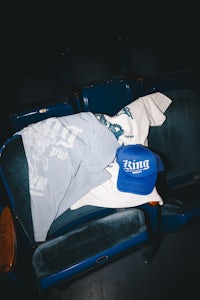 a king t - shirt and a hat on a blue chair in an auditorium
